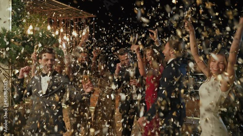 Group of happy people in formalwear dancing and having fun together 