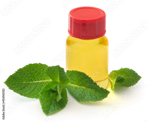 Mint leaves with essential oil in a bottle