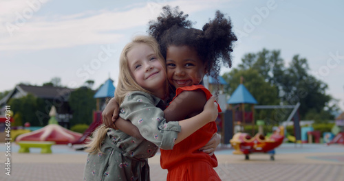 Diverse happy kids hugging on children playground photo
