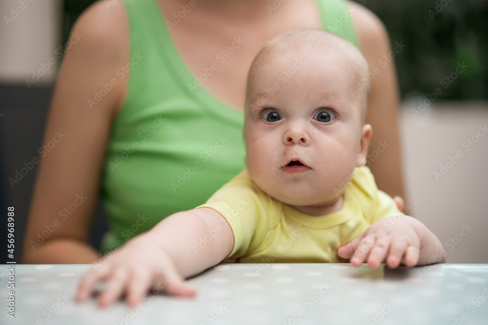 Portrait of cute baby boy enjoys sitting in mother's lap. Portrait of cute baby boy enjoys sitting in mother's lap.