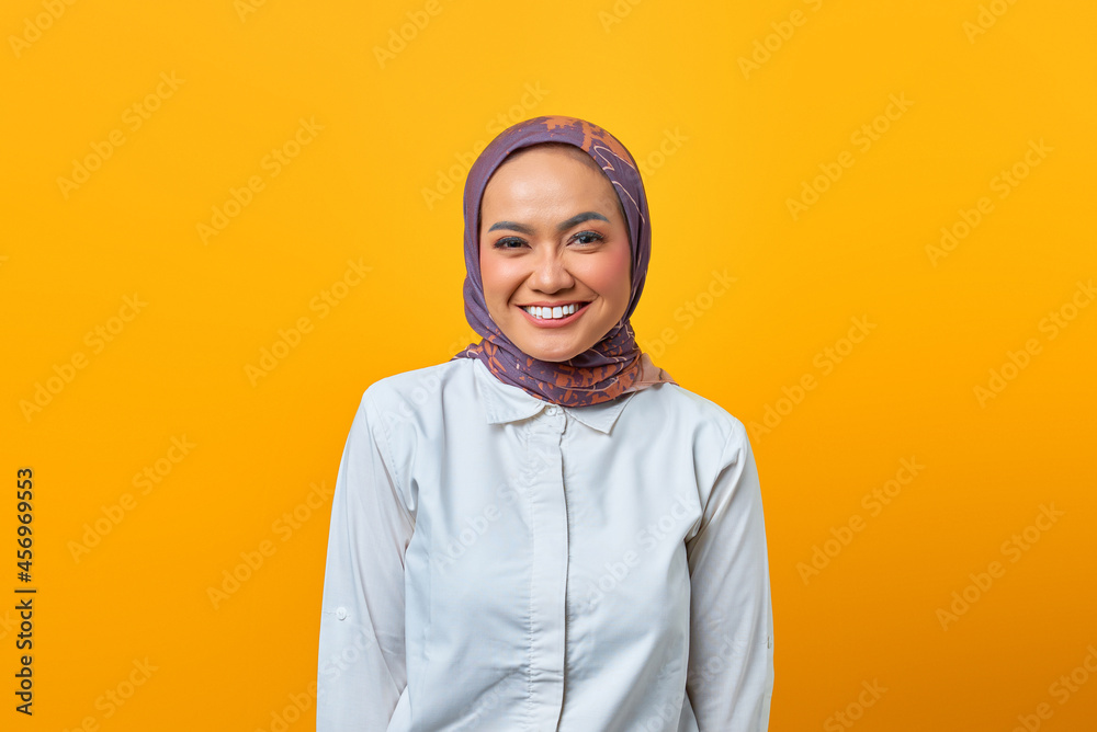 Portrait of beautiful Asian woman with smiling expression over yellow background Portrait of beautiful Asian woman with smiling expression over yellow background