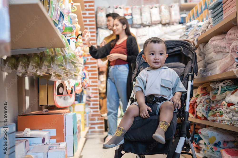 father and mother shopping at the baby shop with their son in the stroller
