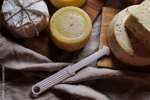 Homemade farm cheese heads and cheese slicer on the table top view. Organic farm cheese, healthy food