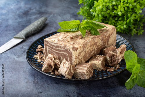 Marble halva on a plate in a cut with a knife. photo