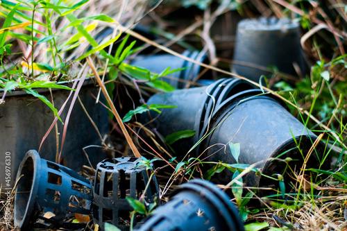 Black plastic plant pots scattered on the ground.