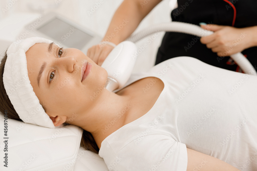 Young woman having laser hair removal procedure of face zone by specialist in cosmetic center. Removes pigmentation in cosmetic clinic. Intensive Pulsed Light Therapy. Anti-aging treatments. Young woman having laser hair removal procedure of face zone by specialist in cosmetic center. Removes pigmentation in cosmetic clinic. Intensive Pulsed Light Therapy. Anti-aging treatments.