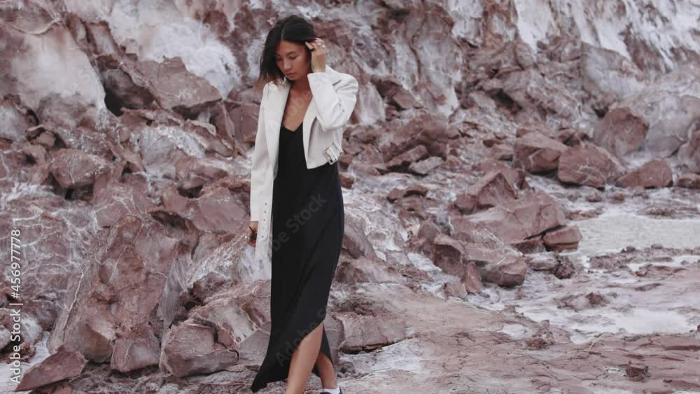 asian woman walking in a futuristic cosmos place across the mountains near water and white sand asian woman walking in a futuristic cosmos place across the mountains near water and white sand