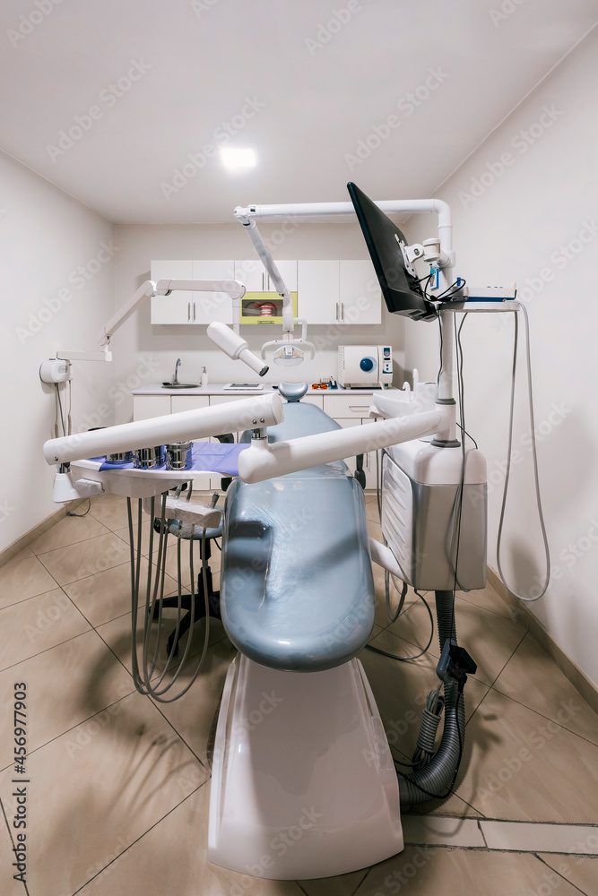 Vertical photo of a stretcher in an empty dental clinic room