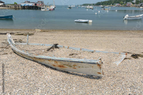 The shell of an old abandoned rowboat sits on the shoreline of Wills Gut on Baileys Island and the working lobstermen harbor in Maine. photo