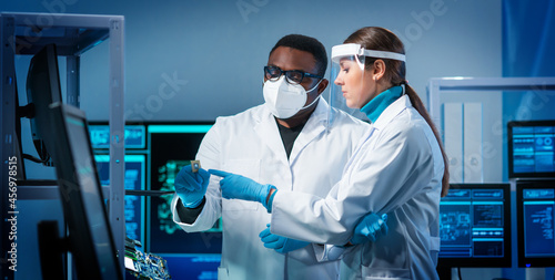 Фототапет Group of microelectronic engineers discussing in a modern microprocessor manufacture lab