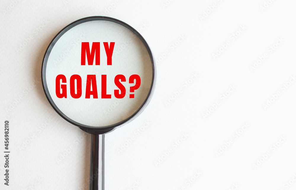 MY GOALS text written on gray background. We read it through a magnifying glass. MY GOALS text written on gray background. We read it through a magnifying glass.