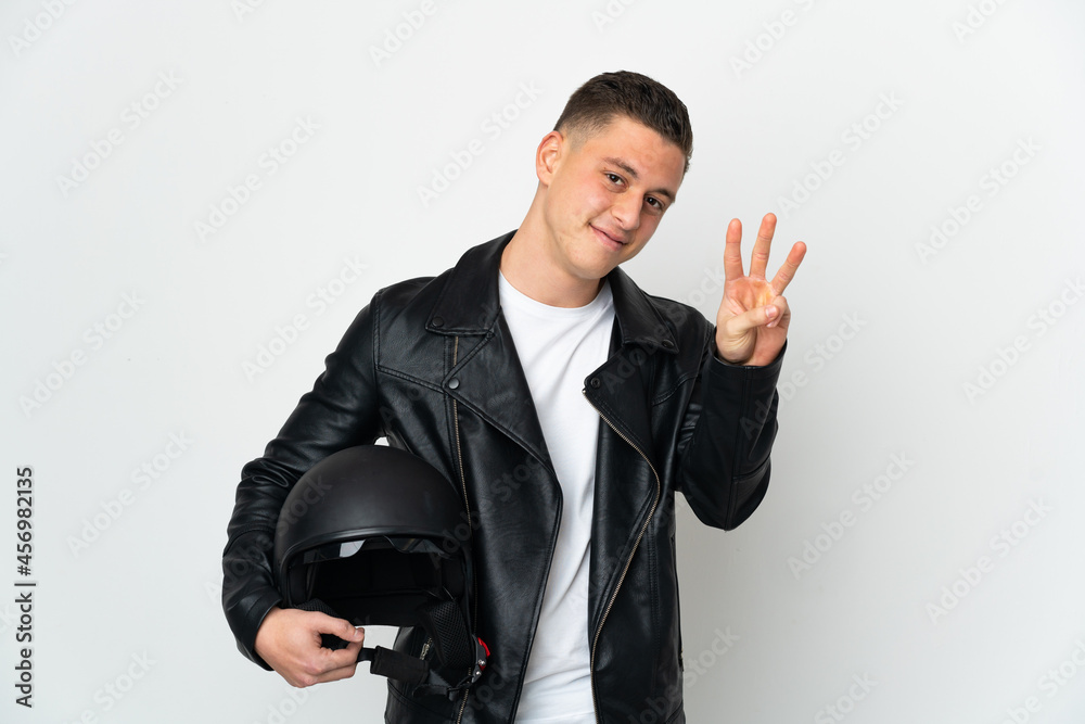 Caucasian man with a motorcycle helmet isolated on white background happy and counting three with fingers Caucasian man with a motorcycle helmet isolated on white background happy and counting three with fingers