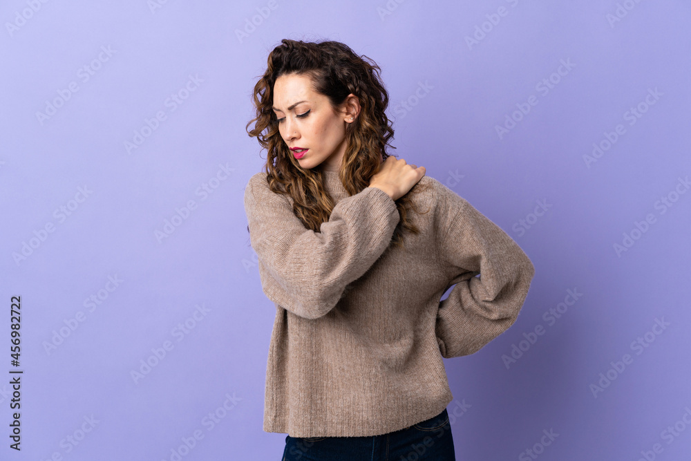 Young caucasian woman isolated on purple background suffering from pain in shoulder for having made an effort