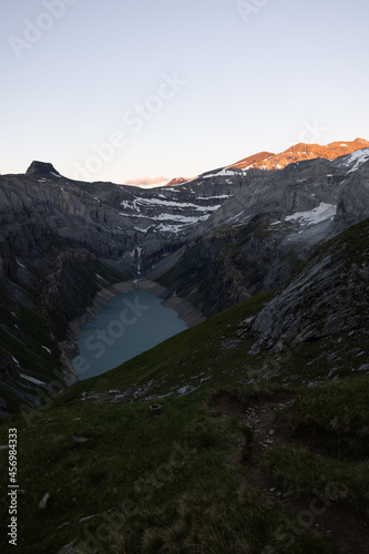 Epic Sunset over an alpine lake called Limmerensee in Switzerland. Wonderful scenery in the alps. The sun shines to the peaks of the mountains. Just amazing.