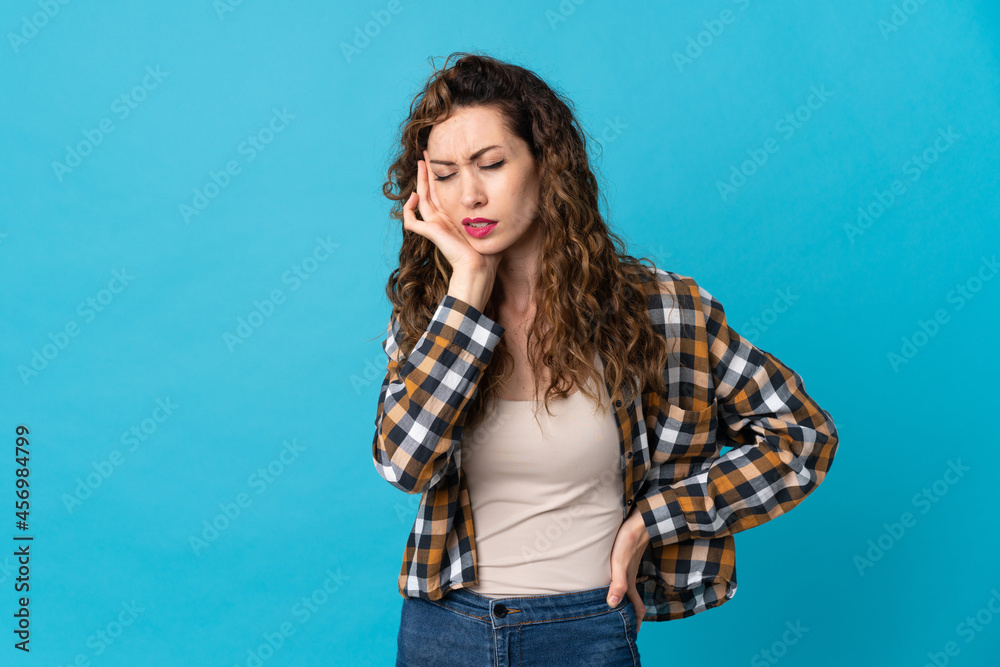 Young caucasian woman isolated on blue background with headache Young caucasian woman isolated on blue background with headache