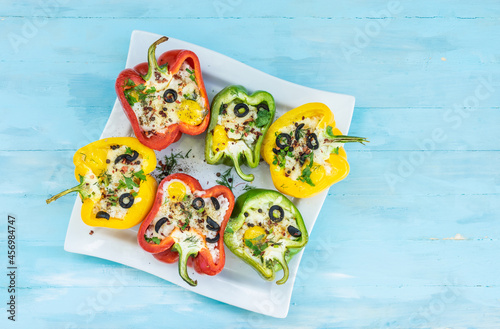 Peppers stuffed with rice and cheese, vegetarian food, wooden background, top view