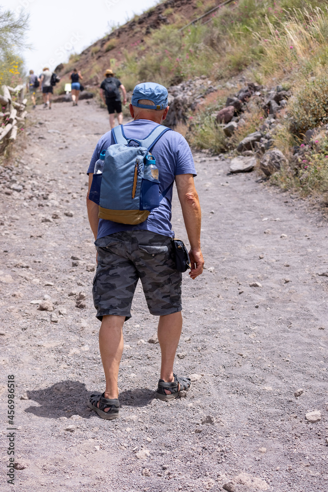 Tourist walking along the footpath to the top of Vesuvius volcano on a hot day, Mount Vesuvius, Italy