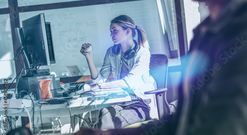 Young female programmer sitting at the desk in her office and working . 