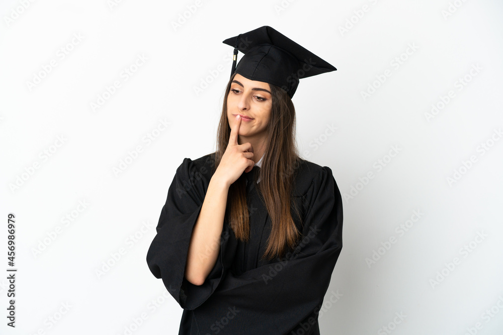 Young university graduate isolated on white background having doubts while looking up Young university graduate isolated on white background having doubts while looking up