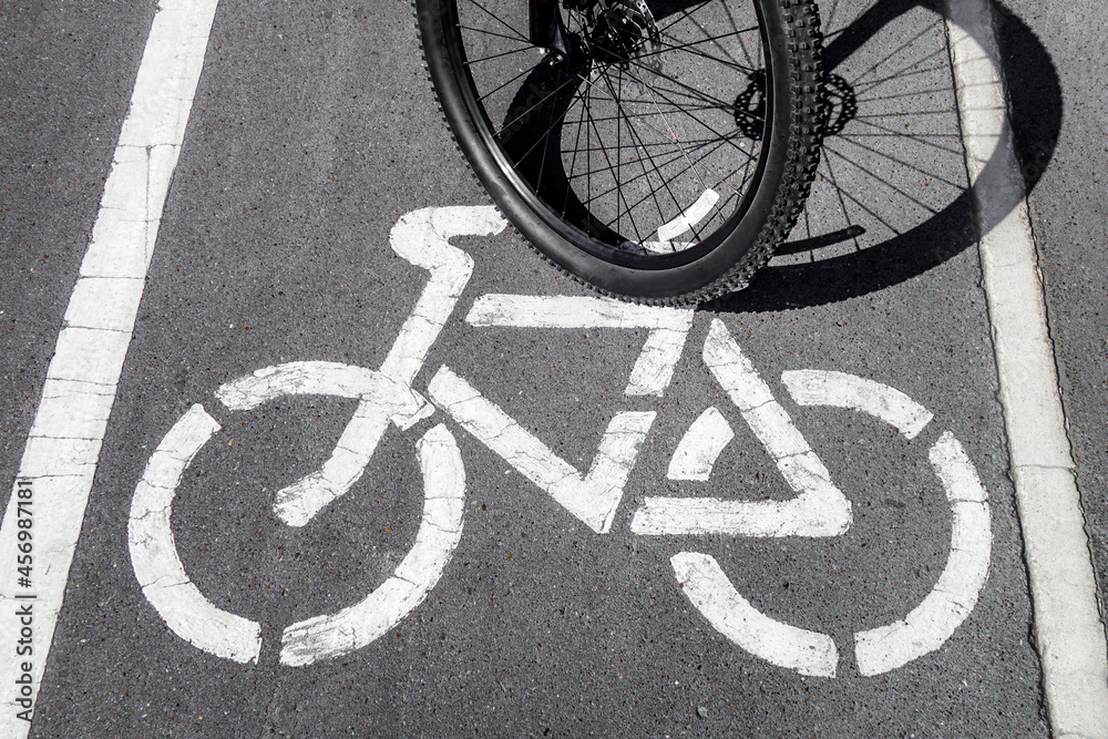Bicycle wheel next to a bicycle painted on the track