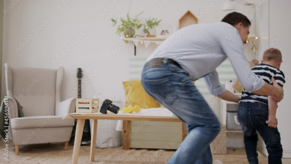 Father with happy down syndrome son indoors at home, having fun. Father with happy down syndrome son indoors at home, having fun.
