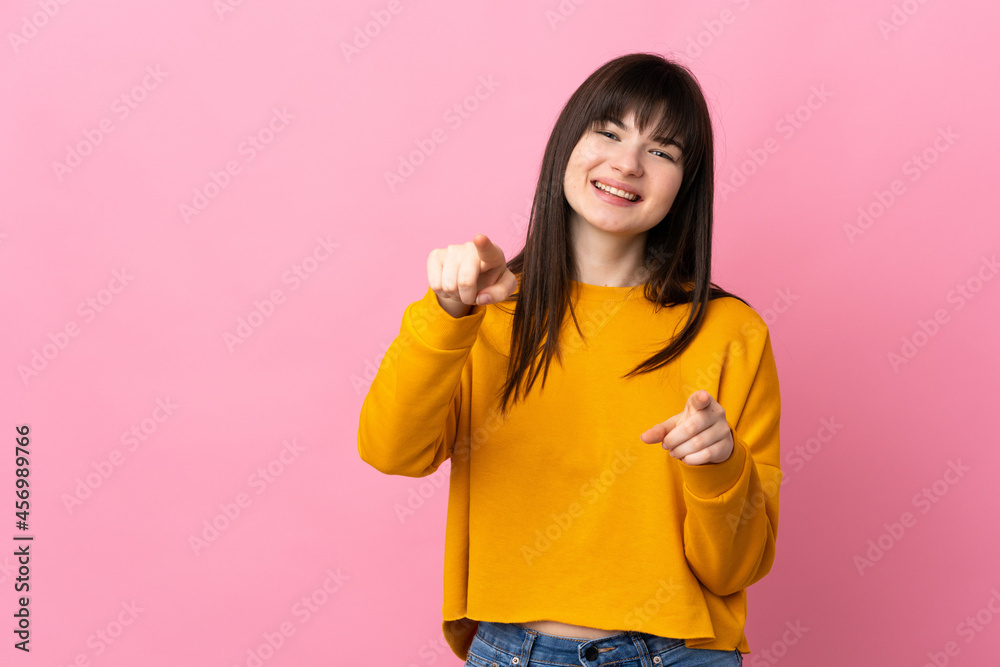 Young Ukrainian woman isolated on pink background pointing front with happy expression Young Ukrainian woman isolated on pink background pointing front with happy expression