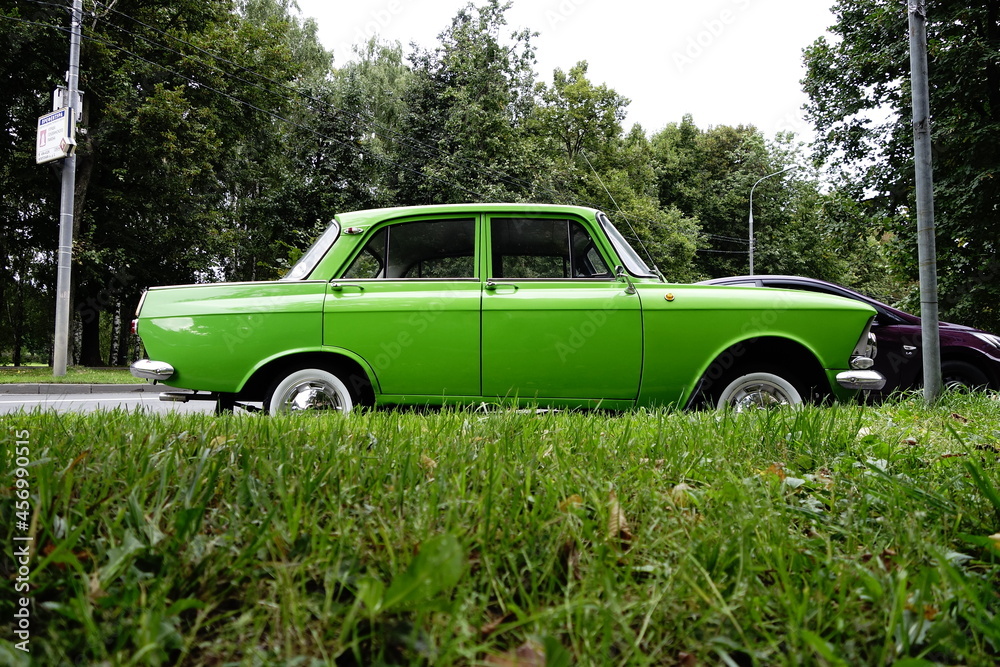 Classic Russian passenger car in green with grass on foreground