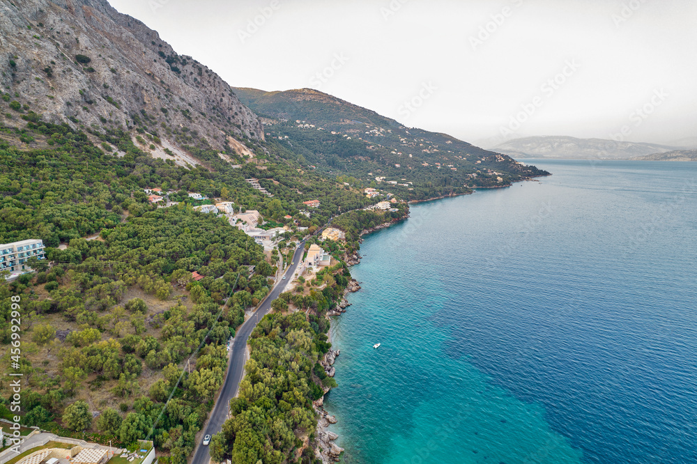 Aerial drone view over rocky coast in Mparmpati, east of Corfu island, Greece. Albania coast in the far distance.