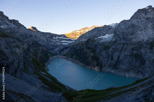 Wonderful sunrise over an alpine lake called Limmerensee in Switzerland. Just an amazing view in the Swiss alps. You see the rocks shined by the sun.