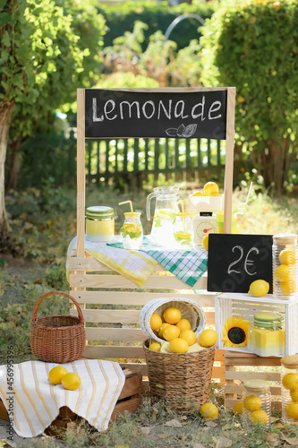 Wooden lemonade stand on green background
