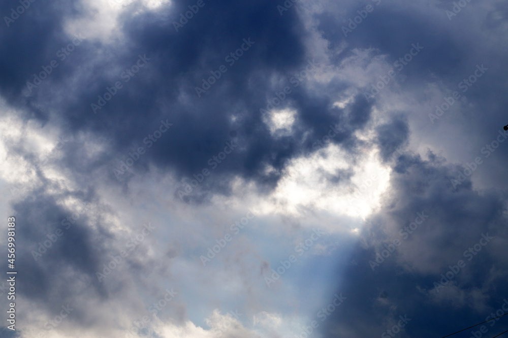 the sun's rays make their way through the dark stormy sky