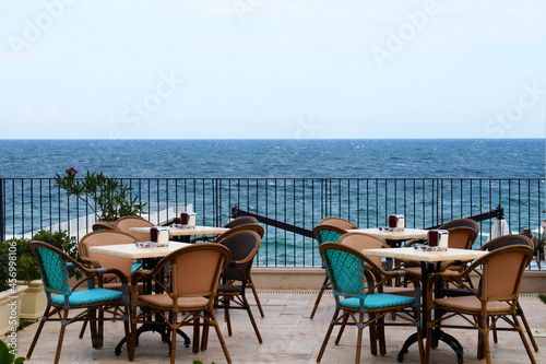 empty tables and chairs of the summer restaurant on the background of the sea horizon  outdoor cafe on the sea