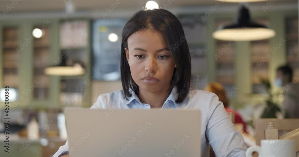 Portrait of young beautiful afro businesswomen enjoying coffee during work on laptop in cafe Portrait of young beautiful afro businesswomen enjoying coffee during work on laptop in cafe