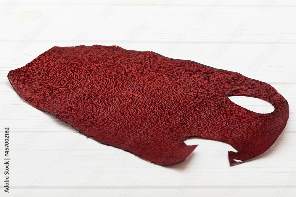 Fototapeta premium Red natural colored rays leather on the wooden table
