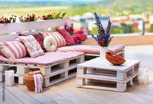 cute, cozy pallet furniture with colorful pillows at summer patio, lounge outdoor space photo