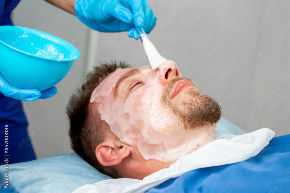 A man at a beautician's appointment. Treatments for men, face cleansing, skin peeling, moisturizing nourishing facial mask. Male spa salon. A man at a beautician's appointment. Treatments for men, face cleansing, skin peeling, moisturizing nourishing facial mask. Male spa salon.