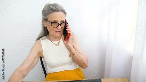 Closeup portrait of angry upset senior mature businesswoman talking with someone at the office. Negative emotion, facial expression, scandal photo