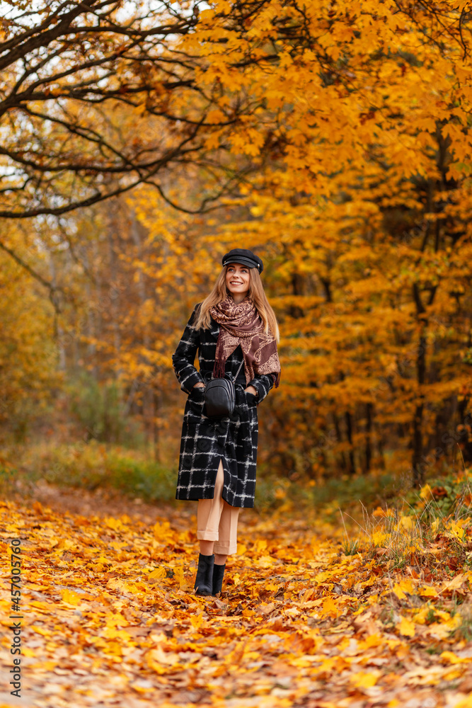 Pretty happy woman with smile in fashion clothes walks in autumn forest with colorful yellow leaves Pretty happy woman with smile in fashion clothes walks in autumn forest with colorful yellow leaves