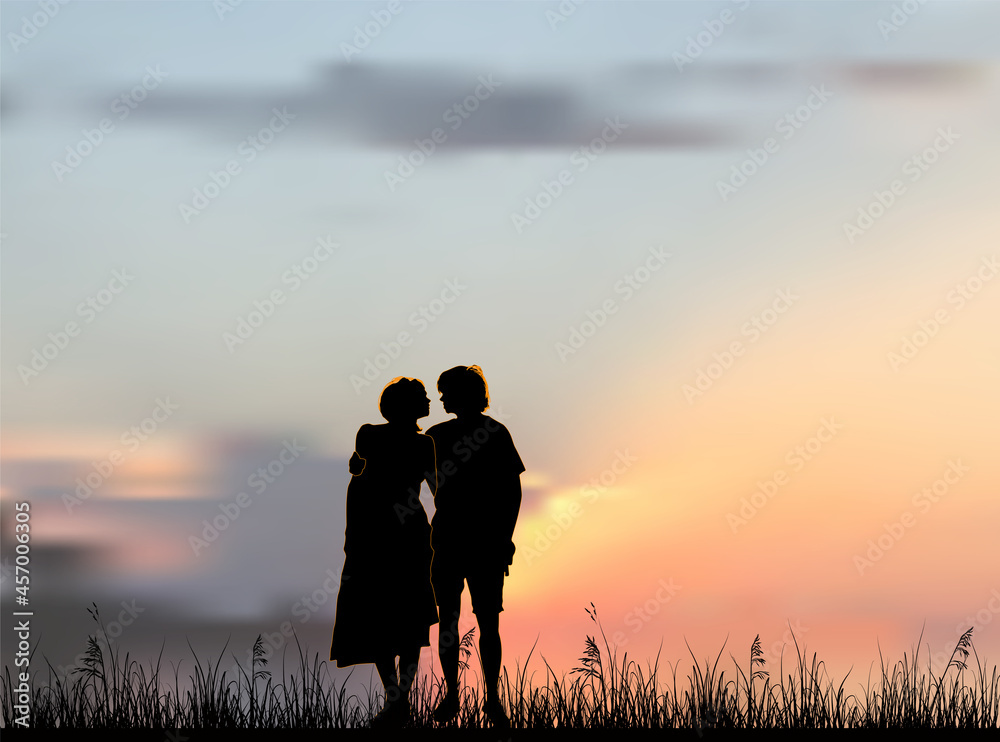 man and woman in grass at sunset