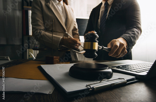 Business and lawyers discussing contract papers with brass scale on desk in office. Law, legal services, advice, justice and law concept picture with film grain effect