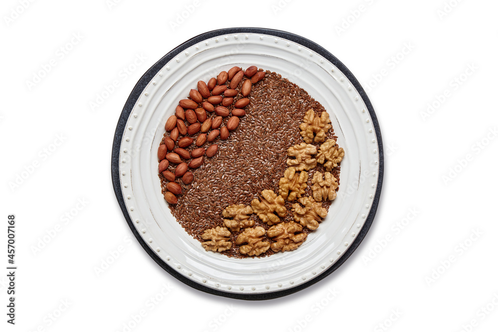 White plate with flax seeds, peanuts and walnuts isolated on white White plate with flax seeds, peanuts and walnuts isolated on white