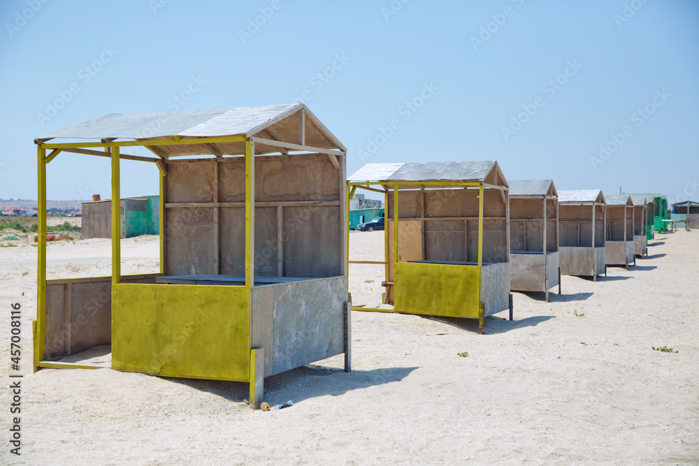 Naklejka premium Houses on the beach of Caspian Sea . Summer Background . the seaside . wooden houses by the beach in Caspian Sea . Cabins at the sand beach. Sea sand . Beach huts .