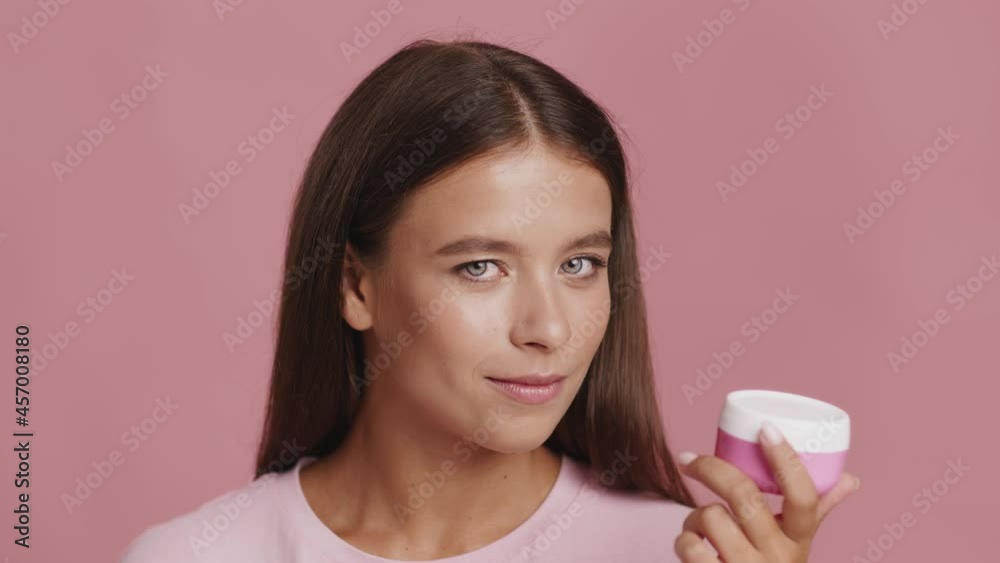 Lady Holding Cream Moisturizer Jar Nodding Head On Pink Background Lady Holding Cream Moisturizer Jar Nodding Head On Pink Background