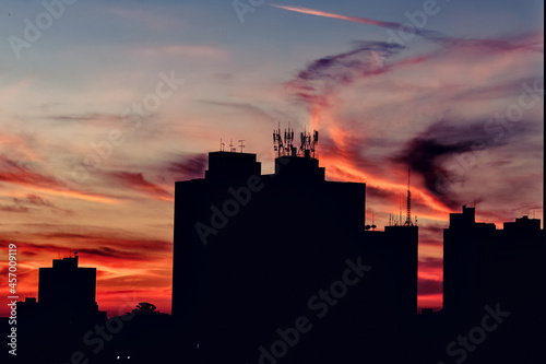 Silhueta de prédios na área urbana de São Carlos São Paulo com o céu colorido pelo por do sol