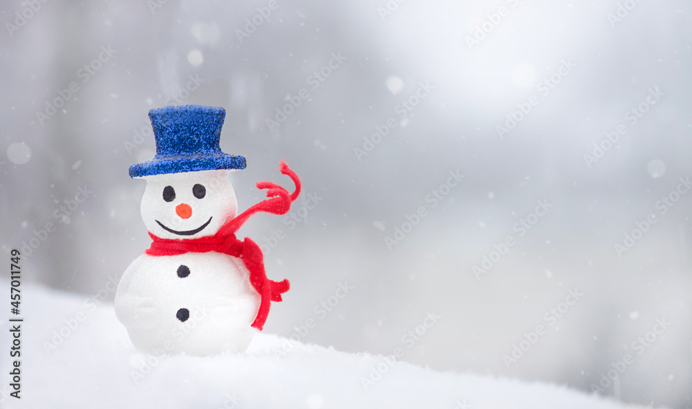 Snowman with red scarf on white snow background. Winter holidays. Christmas time. Copy space. 