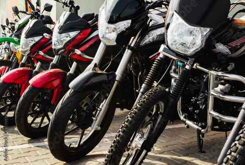 Photo of new motorcycle vehicles standing on store parking.