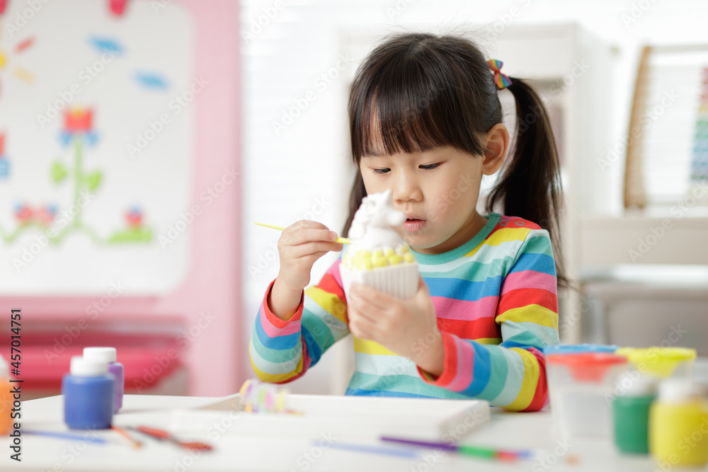 young girl painting money bank craft for homeschooling young girl painting money bank craft for homeschooling