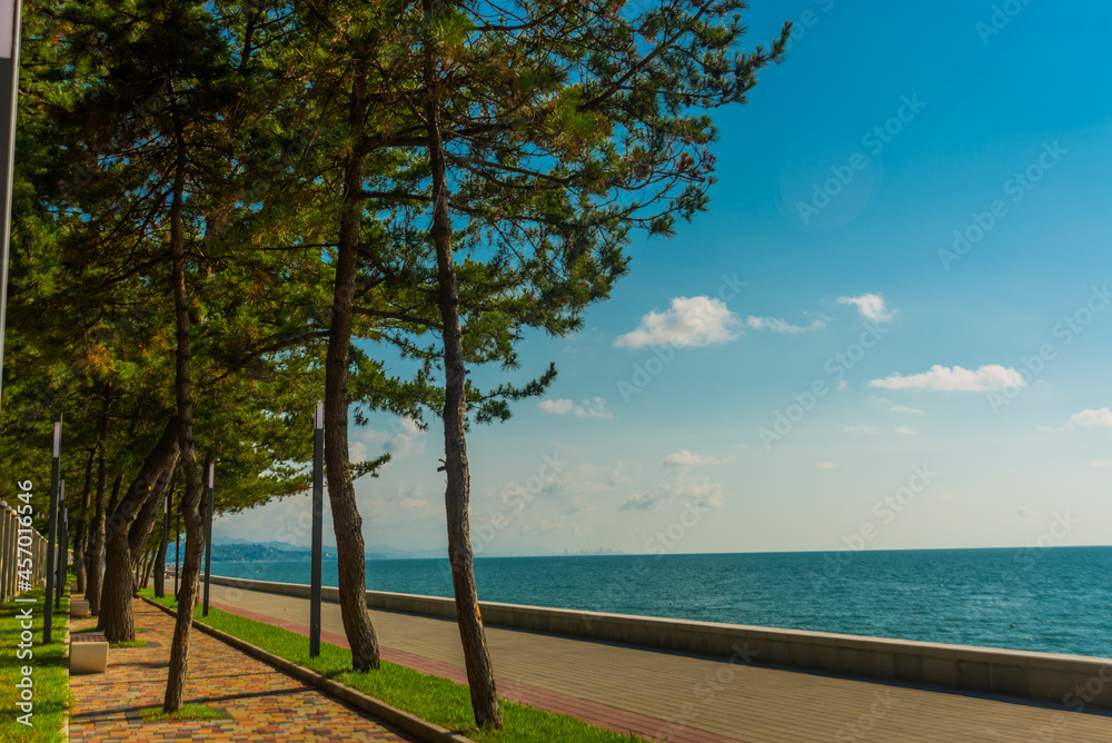 KOBULETI, GEORGIA: Landscape with a view of the promenade by the beach on the Black Sea on a sunny summer day. KOBULETI, GEORGIA: Landscape with a view of the promenade by the beach on the Black Sea on a sunny summer day.