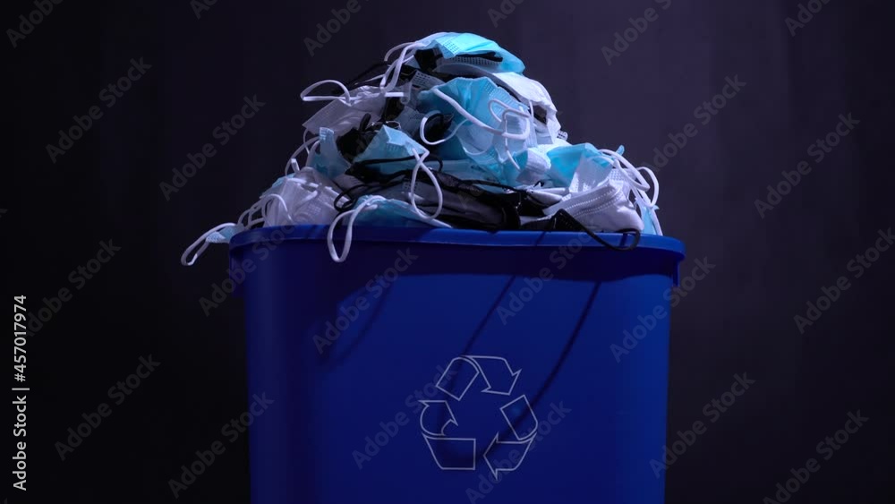 Medical masks in the recycle bin. Reusing and recycling of used