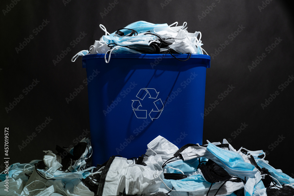 Medical masks in the recycle bin. Reusing and recycling of used personal protective equipment